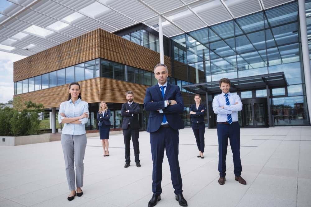 Group of confident businesspeople standing outside office building